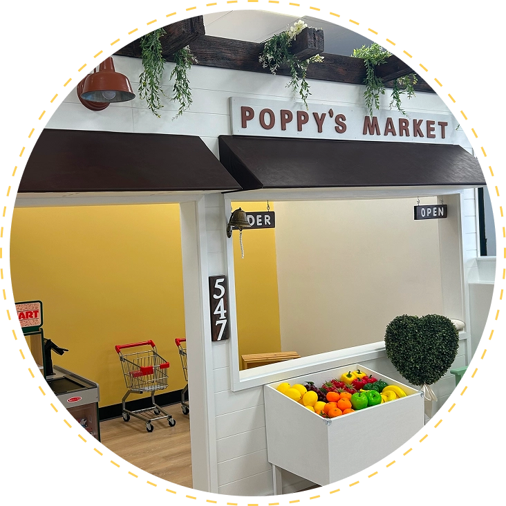 A small indoor market stall named Poppy's Market with fresh produce.