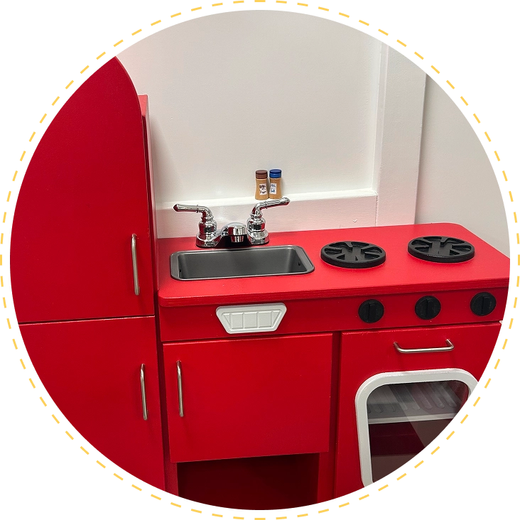 Bright red toy kitchen set with stove and refrigerator.